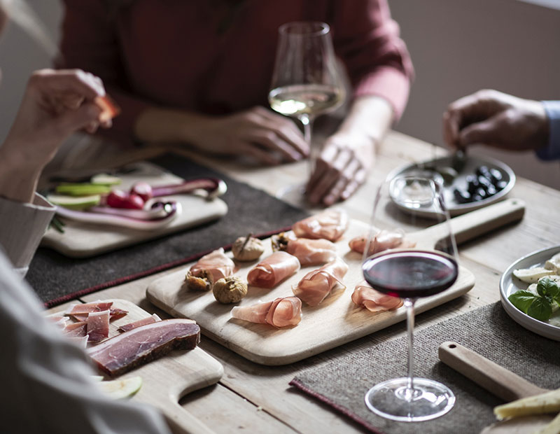 Brettchen mit verschiedenen Produkten, darunter Feigen und Speck.