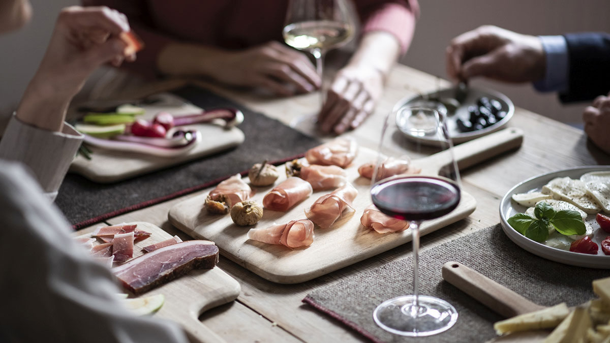 Brettchen mit verschiedenen Produkten, darunter Feigen und Speck.