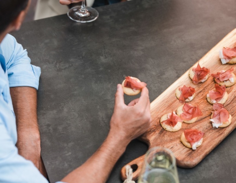 Ein Mann probiert Speckvorspeisen.