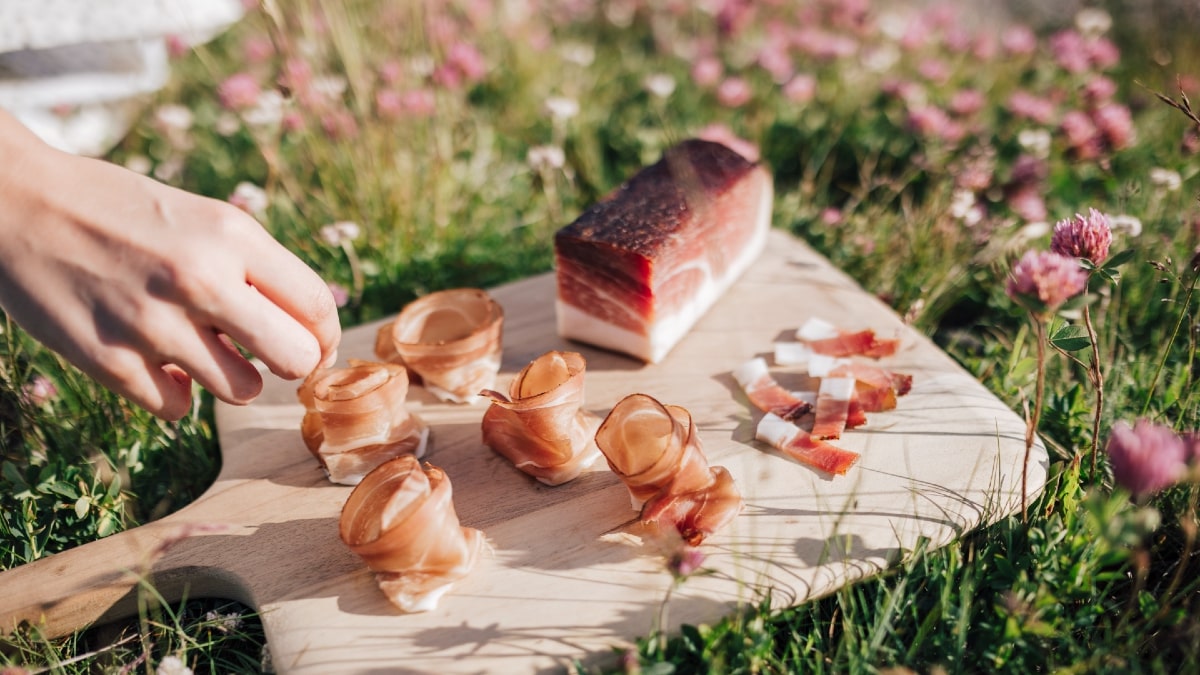 Aufgerollte Speckscheiben auf dem Schneidebrett