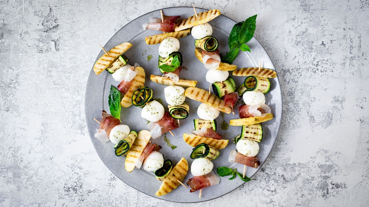 Spiedini estivi con Speck Alto Adige IGP, zucchine grigliate, bocconcini di mozzarella e fettine di mela.