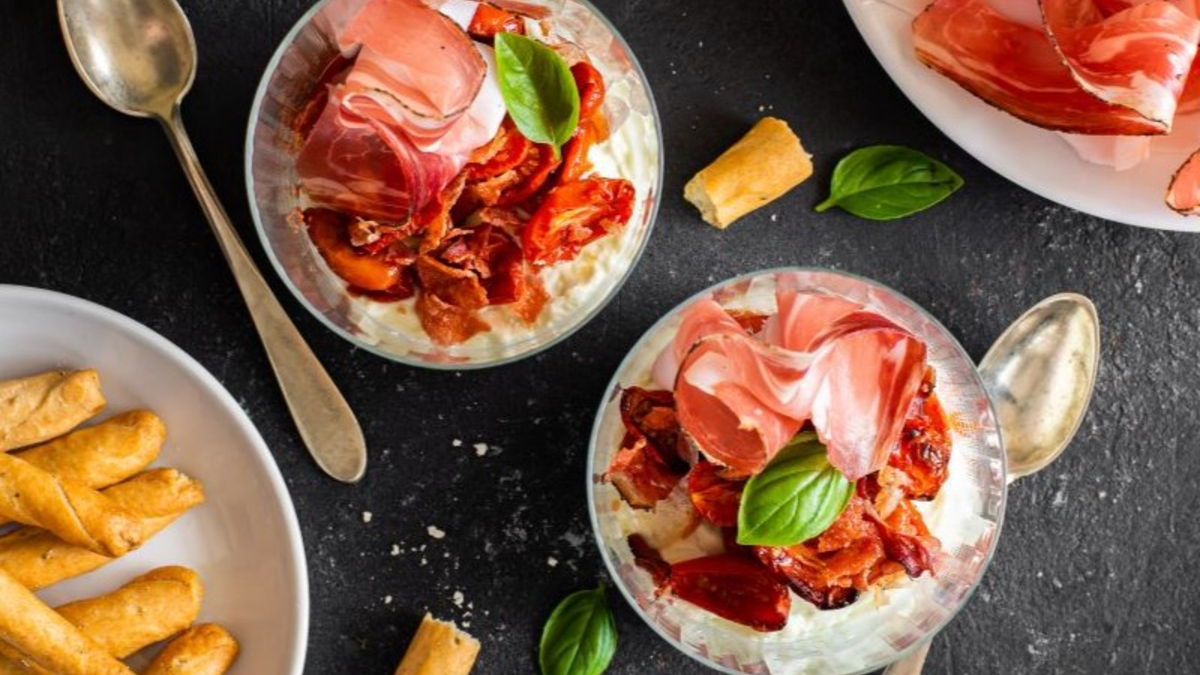 Crema di mozzarella di bufala con Speck Alto Adige IGP, servita in bicchieri con pomodori secchi.