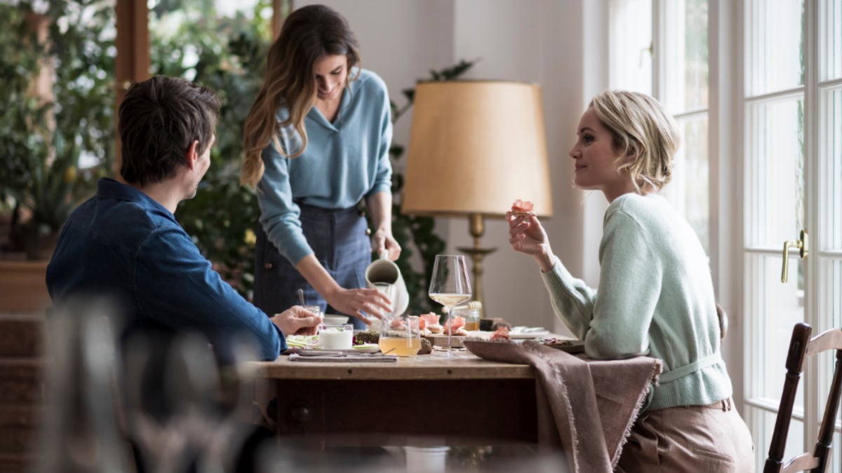 Tre giovani si godono dei prodotti al tavolo