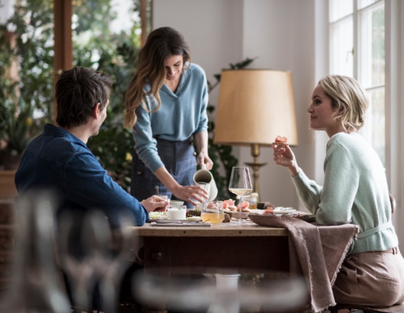 Drei junge Leute genießen Produkte am Tisch.