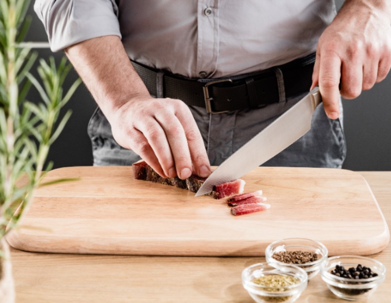 Ein Mann schneidet Speck.