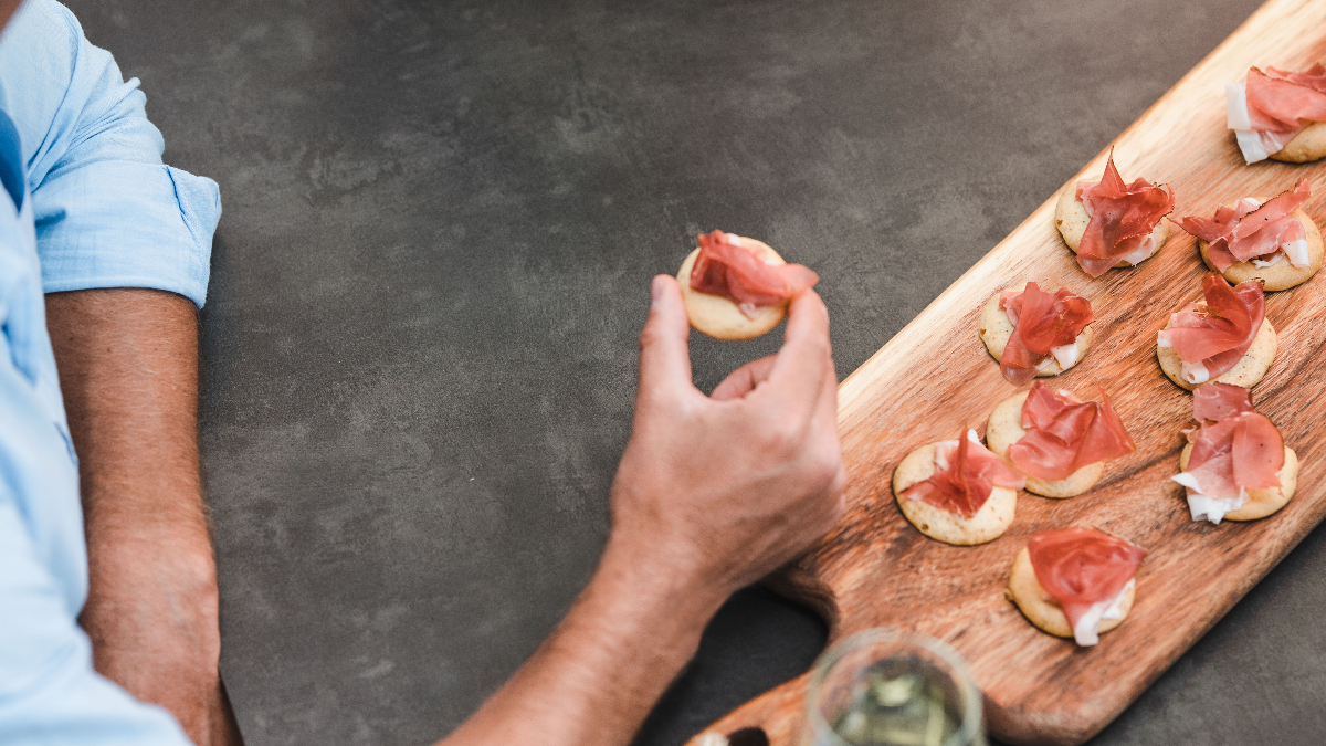 Ein Mann probiert Speckvorspeisen.