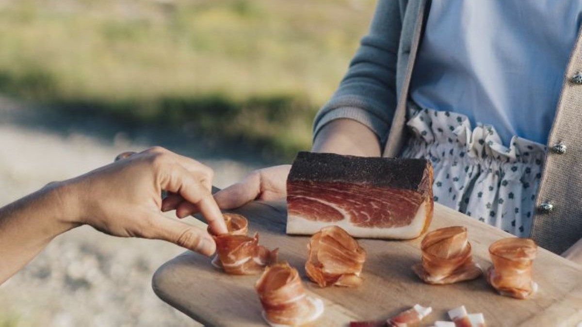 Auf dem Schneidebrett aufgerollter Speck.