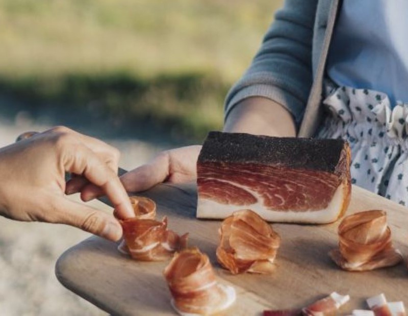 Auf dem Schneidebrett aufgerollter Speck.