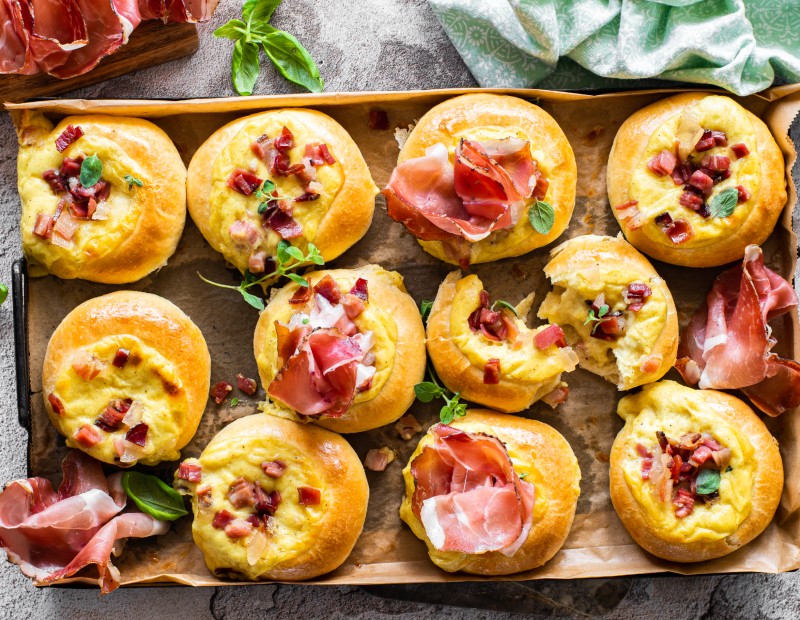 Ein Teller voller leckerer Buns mit Käsebéchamel und Südtiroler Speck g.g.A.